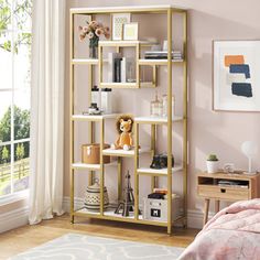 a bedroom with pink walls and a gold shelving unit