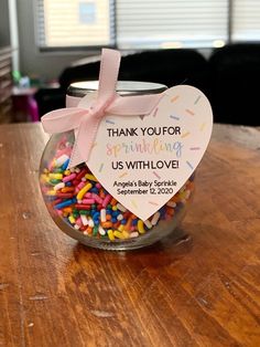 a jar filled with sprinkles and a pink bow