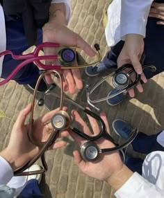 several doctors are holding their stethoscopes together