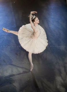 a black and white photo of a ballerina in the middle of a dance pose