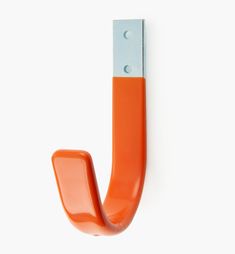 an orange door handle on a white wall in the shape of a letter j,