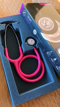 a pink stethoscope sitting in a blue box on top of a table