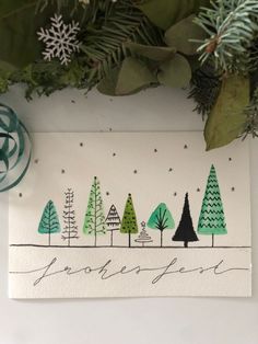 a christmas card with trees and snowflakes in the background, surrounded by greenery