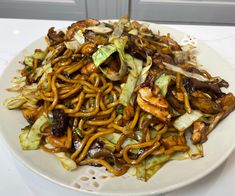 a white plate topped with noodles and vegetables