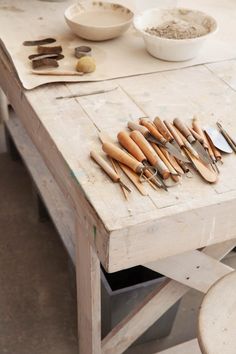 a wooden table topped with lots of different types of utensils on top of it