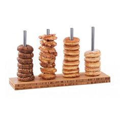 an assortment of doughnuts and pastries arranged on a wooden board with metal posts