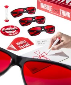 a pair of red tinted sunglasses with stickers and ink on the lens, including an invisible ink pen