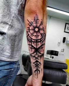 a man with a compass tattoo on his arm