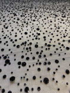 water droplets on the surface of a mesh cloth with white and black dots all over it