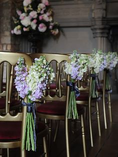 the chairs are lined up with purple and white flowers