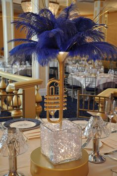 a table topped with a musical instrument and blue feathers