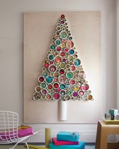 a christmas tree made out of toilet paper rolls is displayed on the wall in this room