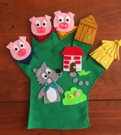 a green felt bag with farm animals and houses on the front, sitting on a wooden surface