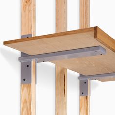 a wooden shelf with metal brackets attached to it