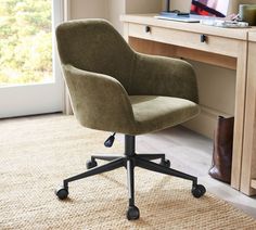 an office chair sitting on top of a rug in front of a desk with a laptop