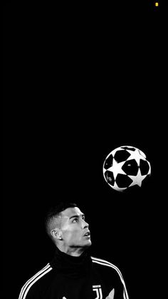 a man in black and white with a soccer ball on his head looking up at the sky