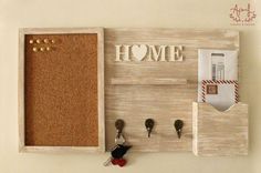 a cork board with key hooks and magnets attached to it that says home on the wall