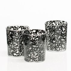 three black and white shot glasses sitting next to each other