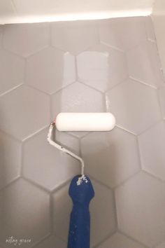 a blue and white toilet in a bathroom with hexagonal tiles on the wall