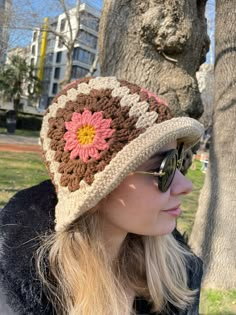 a woman wearing sunglasses and a crocheted hat