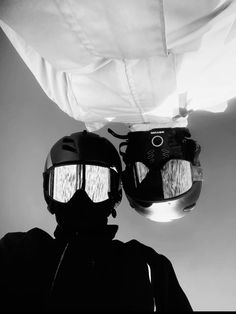 two people wearing helmets and goggles under a white sheet