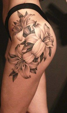 a woman's thigh with flowers tattooed on her leg and the bottom part of her thighs