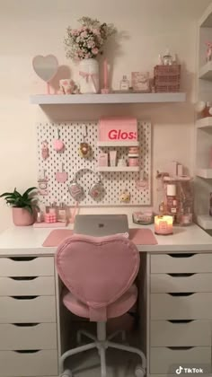 a desk with a laptop on top of it and lots of shelves above the desk