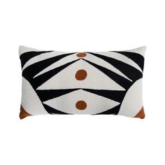 a black and white zebra print pillow with brown dots on it's side, in front of a white background