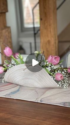 a bouquet of pink flowers sitting on top of a wooden table