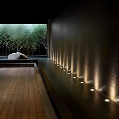 a room that has some lights on the wall and wood flooring in front of it