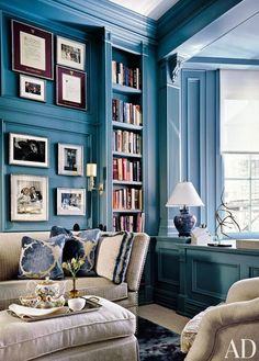 a living room filled with furniture and bookshelves covered in lots of bookcases