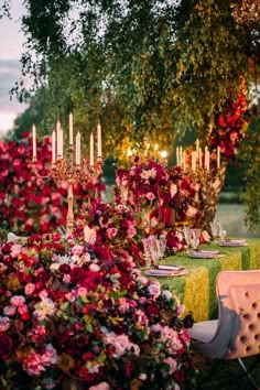 a table with flowers and candles is set up for an outdoor dinner or party in the evening