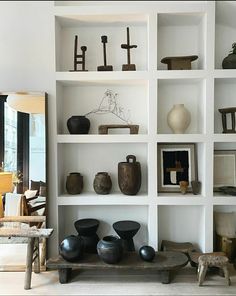 the shelves are filled with vases and other decorative items in black and white colors