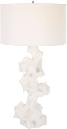 a white table lamp with a white shade on it