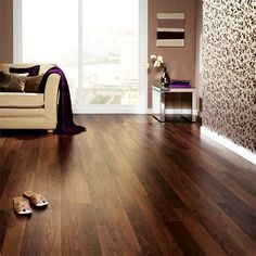 a living room filled with furniture and hardwood flooring next to a wall covered in flowers