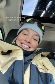 a woman sitting in the back seat of a car with her eyes closed and smiling