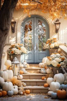 an entrance with pumpkins and flowers on the steps