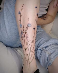 a woman's leg with blue flowers on it