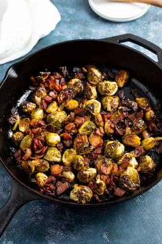 brussel sprouts in a cast iron skillet on a blue surface