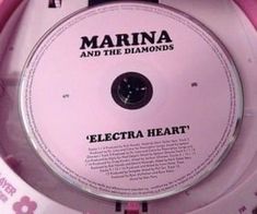 the cd cover for marina and the diamonds'electric heart is shown in its pink case