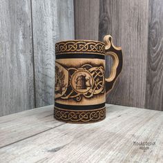 a brown and black mug sitting on top of a wooden table