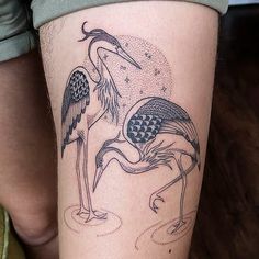 a woman with a tattoo on her leg has an image of two birds in flight