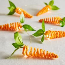 some orange spirals with green leaves on top of white table cloth and one is cut in half