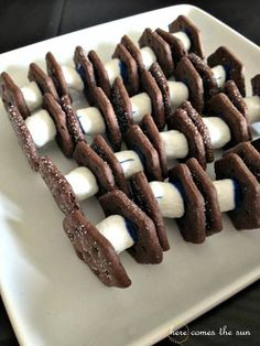 marshmallows and chocolate are arranged on a white plate