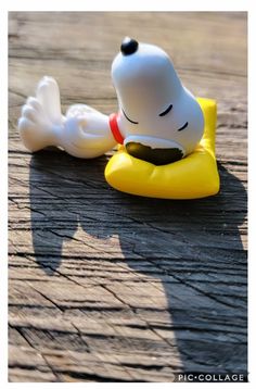 a small toy sitting on top of a wooden floor next to a yellow rubber duck