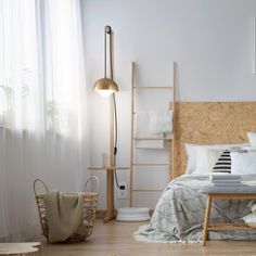 a bedroom with white walls and wooden furniture, including a headboard made out of plywood