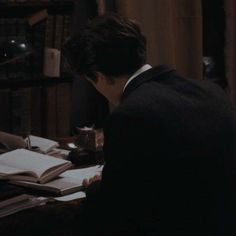 a man sitting at a desk in front of a book and some books on it