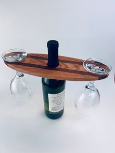 two wine glasses and a bottle on a wooden tray