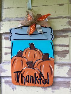 a wooden sign that says, thanks with pumpkins in a mason jar on it