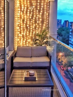 a couch sitting on top of a wooden floor next to a window covered in lights